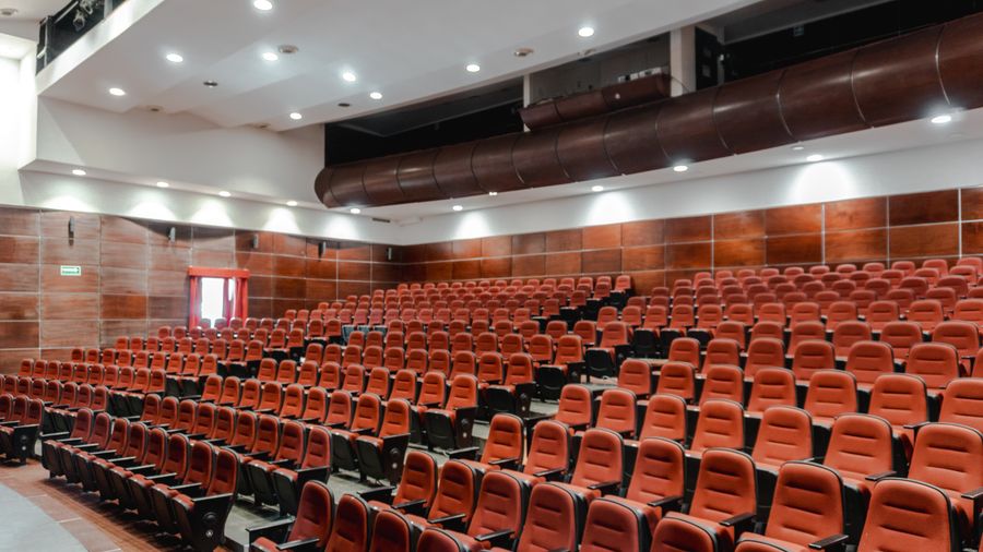 A contemporary theatre auditorium with red seating
