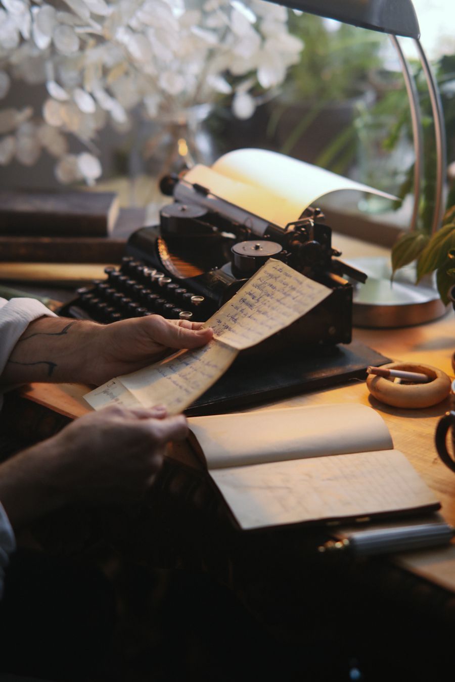 A writer working with paper beside a typewriter